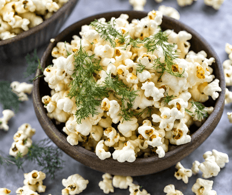 popcorn in a bowl topped with dill weed