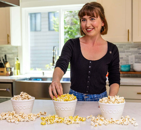 smiling woman with three bowls of popcorn