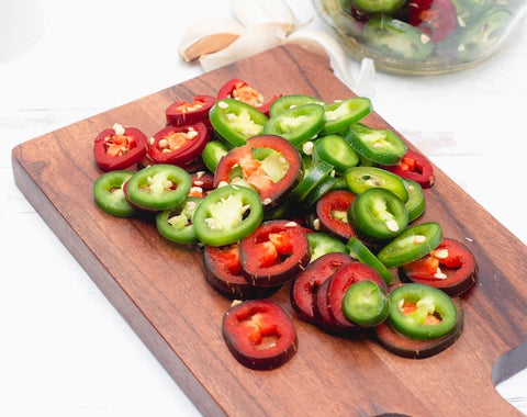 Sliced jalapeno peppers on a cutting board