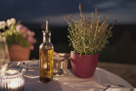 bottle of olive oil beside a plant
