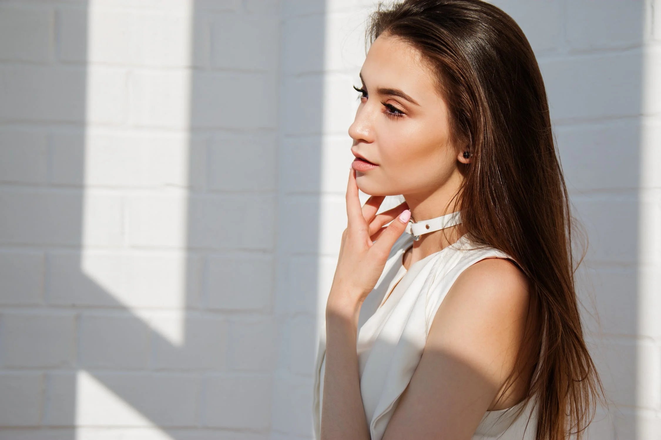 A young woman standing under sunlight