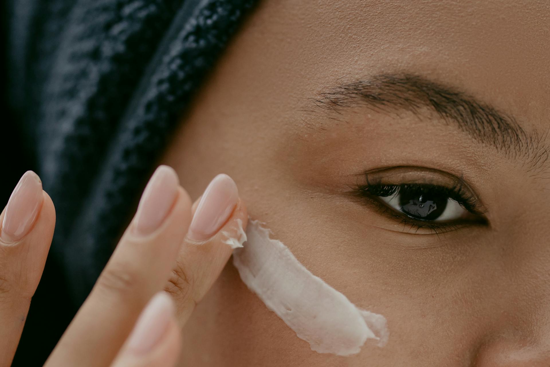 Woman applying eye cream 