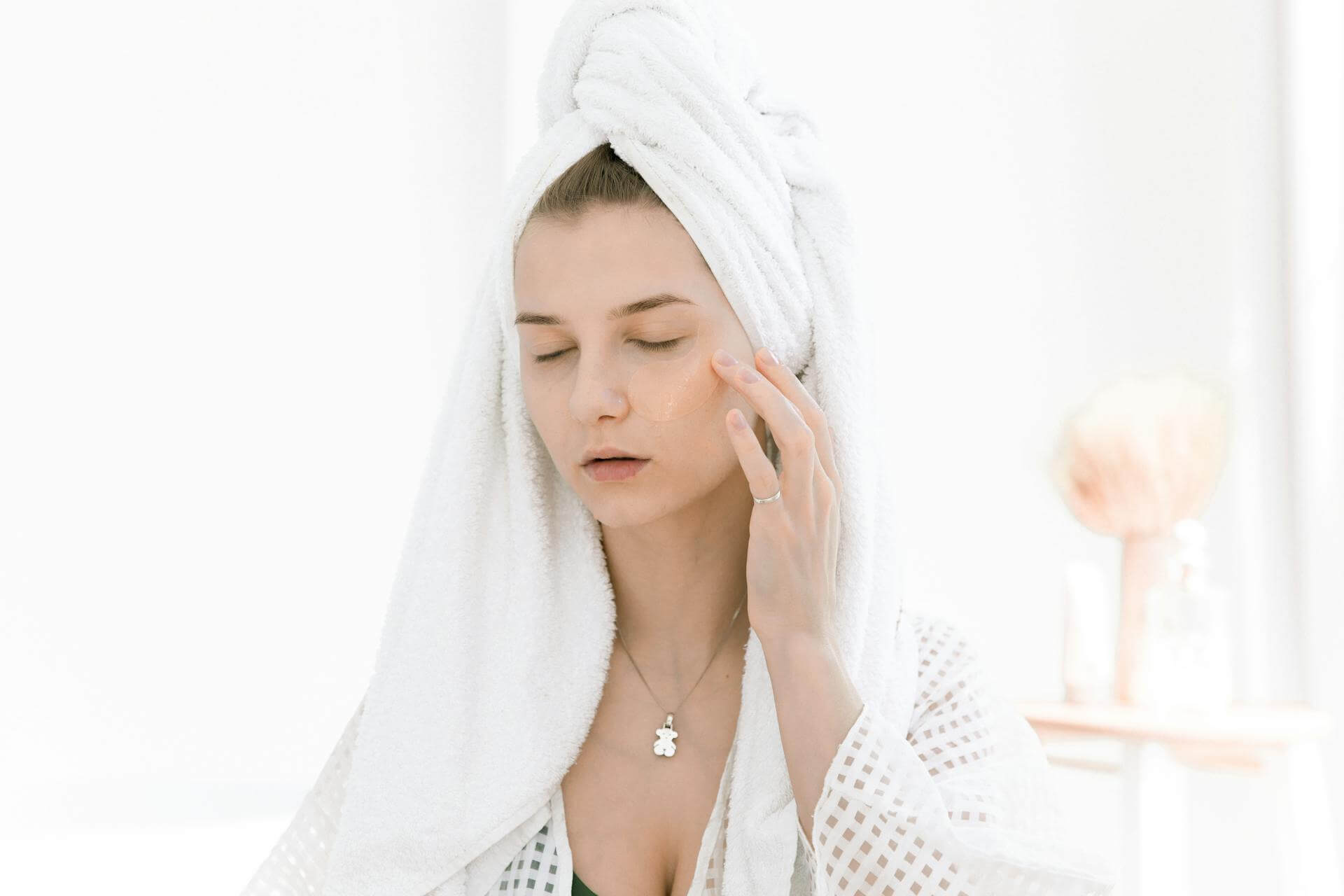 Woman wearing hair towel applying face cream