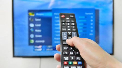 A person is controlling the TV with a remote control