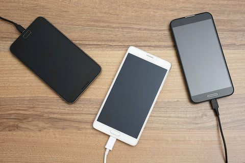 Mobile smartphone charging on wooden table