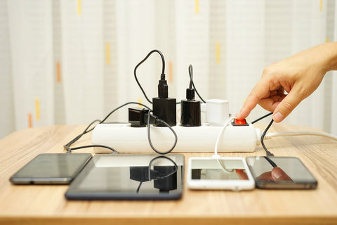 Man is turning off power adapter of mobile phone and tablet