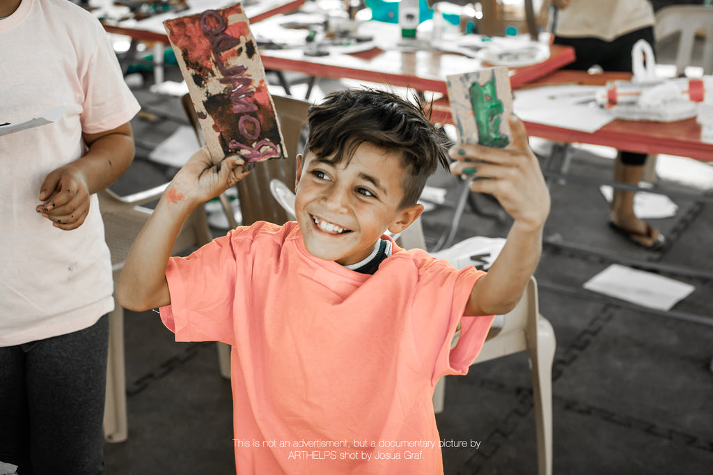 child holding art pieces