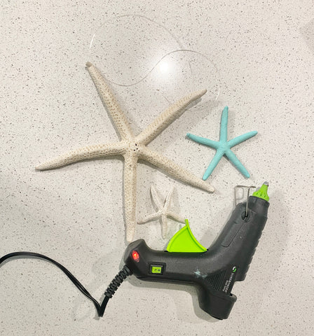 3 various sized starfish, hot glue gun and twine