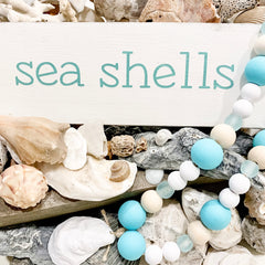 decorating your home with sea shells, an anchored soul beach sign and an oyster garland