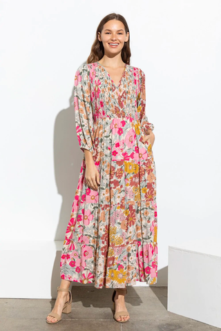 A woman wears a floral printed maxi dress with block heels
