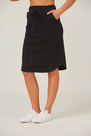 A model wears a cotton skirt and a pair of sneakers. 