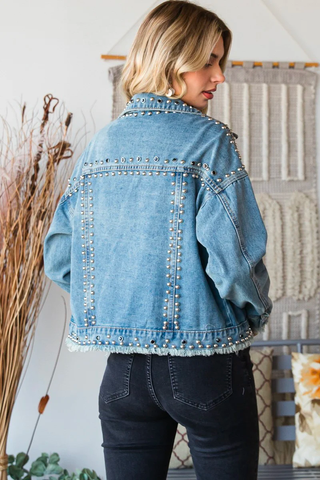 A studded denim jacket cropped at the waist and paired with black jeans.