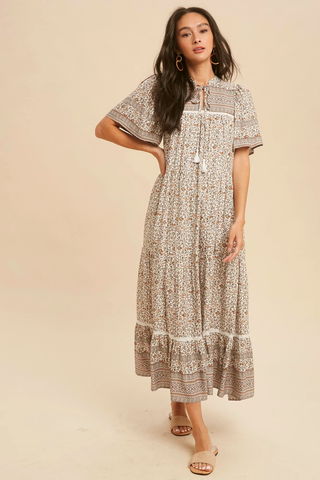 A woman with long, wavy hair wears a boho dress. 