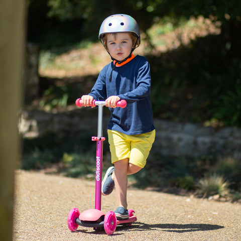 Boy riding Pink Didiscoot ride on