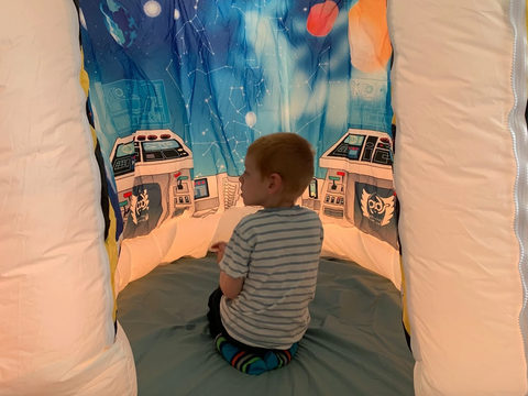 child playing inside galactic space adventure POD