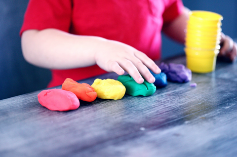 child playing with coloured play-dough 