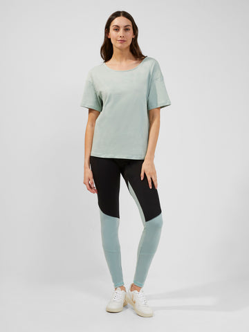 Model wearing pale blue comfy tee and blue and black block colour gym leggings. 