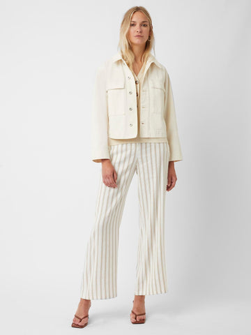 Model wearing cream cropped denim jacket and cream trousers