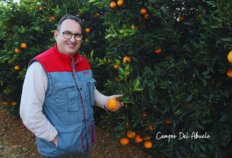 Eduardo posa con una naranja recién cosechada de un naranjero de su campo