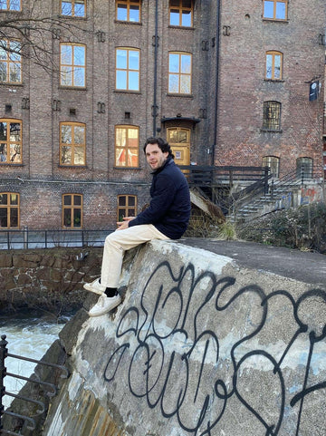 man sitting on a mural wall smiling