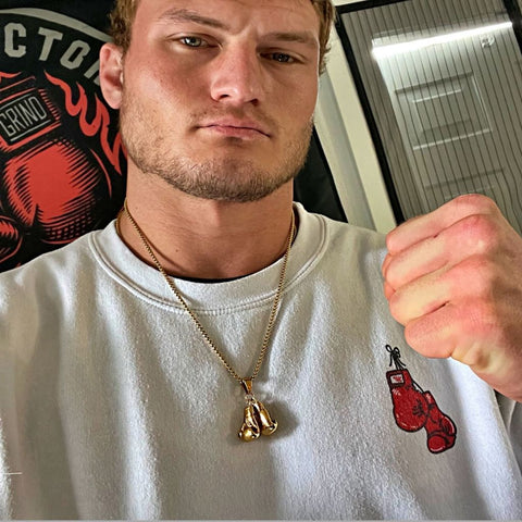 Professional fighter wearing Gold Boxing gloves necklace from King Killers Apparel