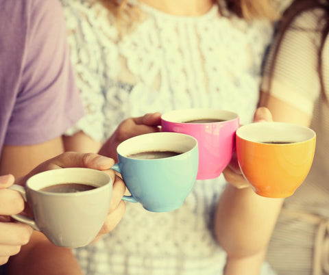 Fresh coffee in cups with a group holding