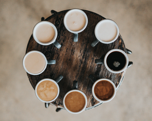 flat-lay-photography-of-eight-coffee-latte-in-mugs-on-round-table