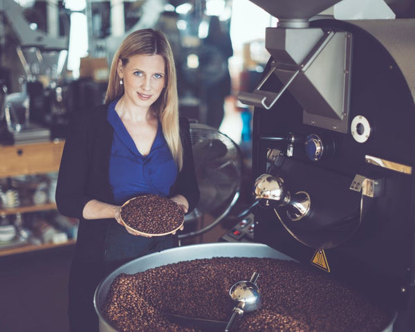 Lady standing at a Perth Coffee Roaster shwoing fresh roasted coffee beans