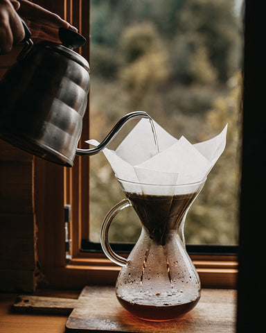 Chemex filter coffee, brewing process, water pouring over coffee grind in filter paper