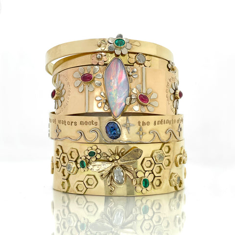 stack of 14K solid gold cuff bracelets with colorful gemstones