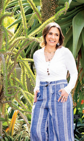 pretty girl in tropical setting with white tee and lots of colorful jewelry