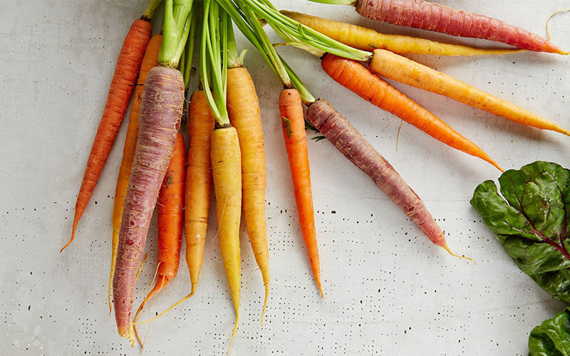 A fresh bunch of multicoloured carrots with the skin on. A good way to boost your daily dietary fibre intake.