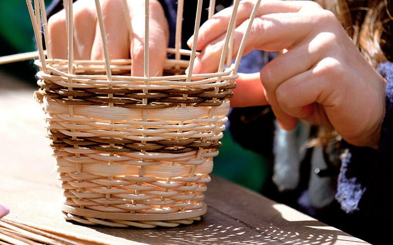 A woman weaving a basket.
