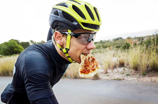Cyclist eat pizza after biking in the rain