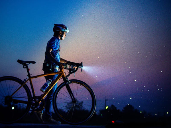 Vététiste portant des lunettes de cyclisme nocturne spécialisées, soulignant leur importance pour la visibilité et la sécurité pendant les balades nocturnes.