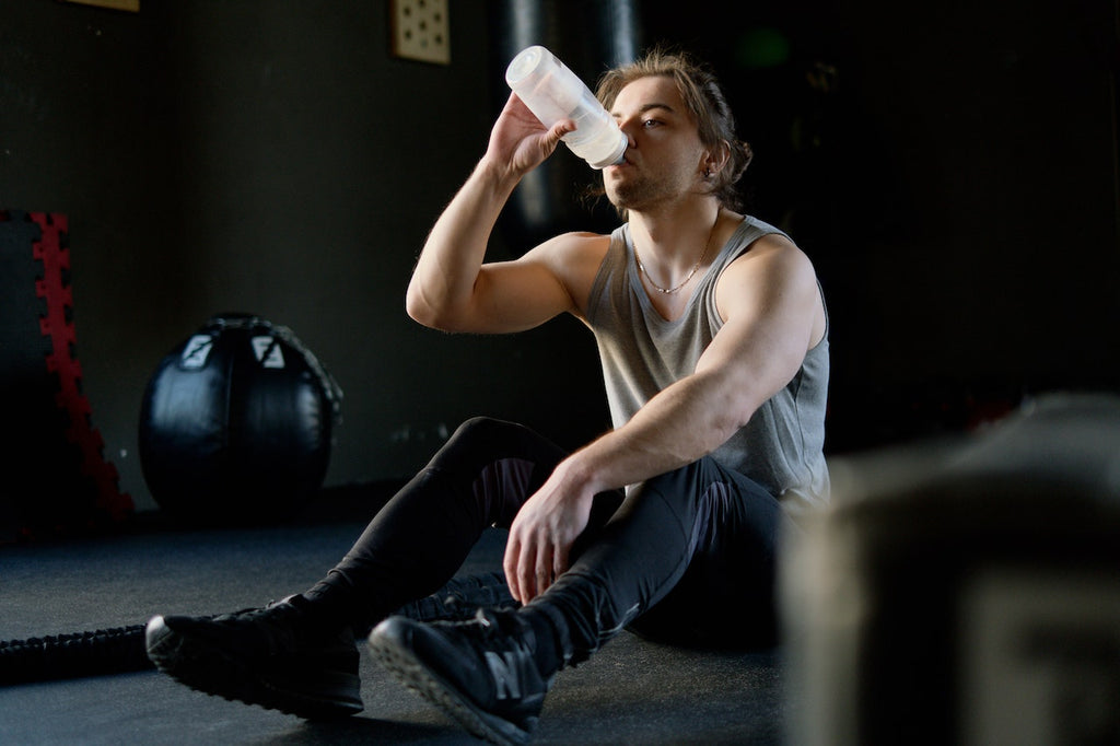 man drinking plastic water bottle