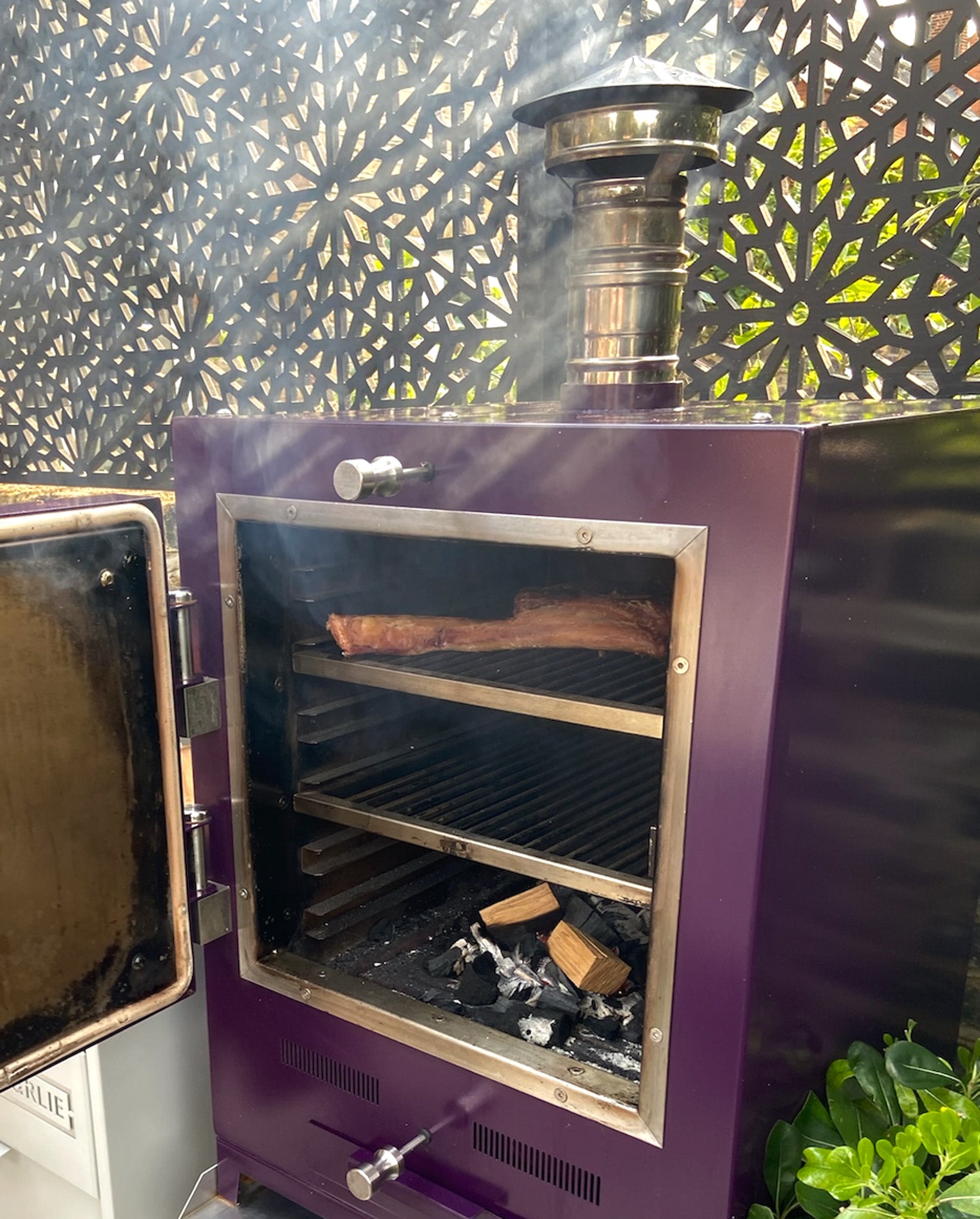 Tomahawk steak inside the Charlie Oven to smoke using wood and charcoal