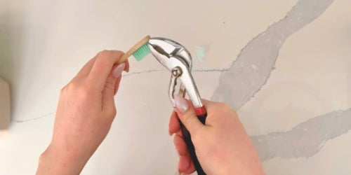 Pliers pulling bristles out of bamboo toothbrush