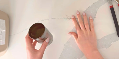 Women picking up metal staples from bamboo toothbrush and adding them to an aluminum can