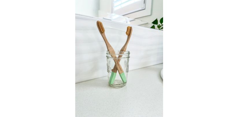 A set of Bamboo toothbrushes in a mason jar 