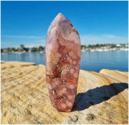 pink amethyst flame near water on sandstone