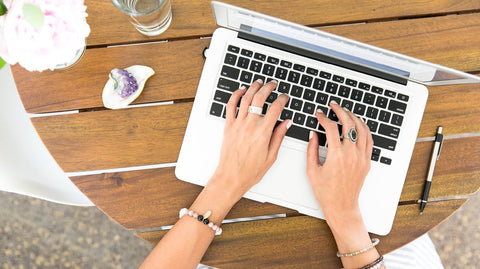 Girl typing on Apple MacBook laptop 