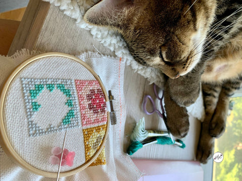 Summer cross stitch along cross stitch art next to sleeping cat | Haley Hamilton Art