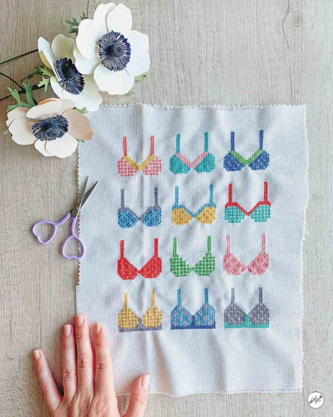 finished cross stitch project of colorful bras for breast cancer awareness month