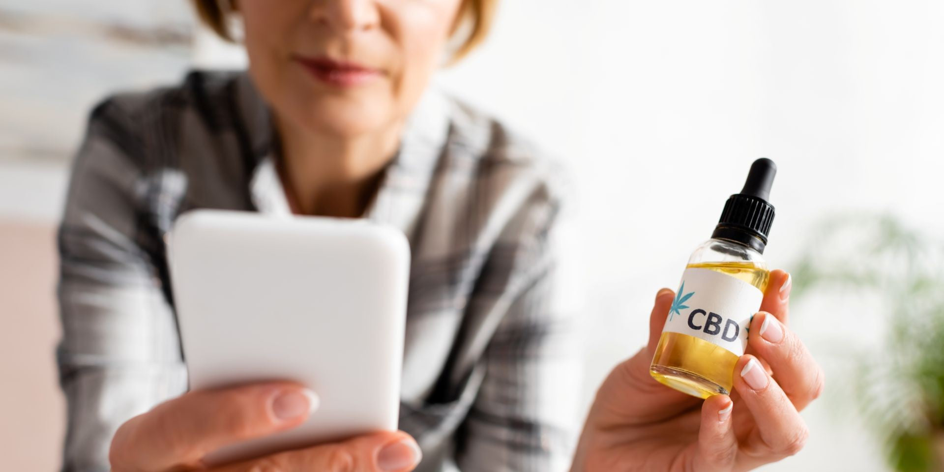 senior woman holding bottle of cbd