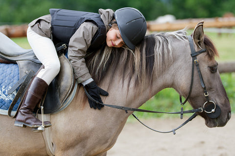 Horse Safety - Child on horse with helmet, boots and vest