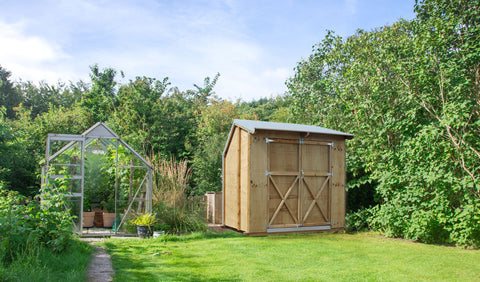 Garden shed with trees overhanging 