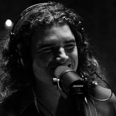 Jonah Hitchens profile image - black and white photo of Jonah singing at a microphone with headphones on