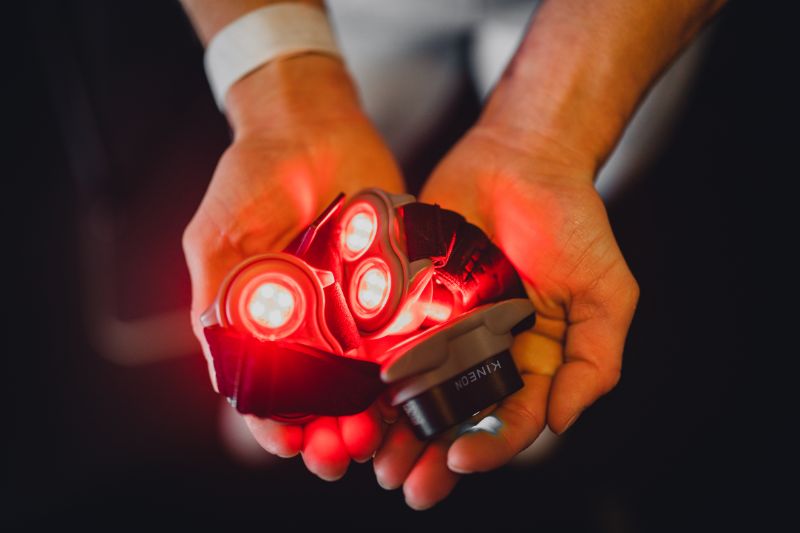 Someone holding red light therapy device