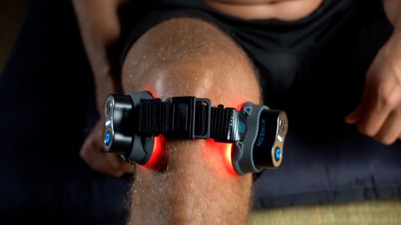 Man wearing red light therapy device on his knee